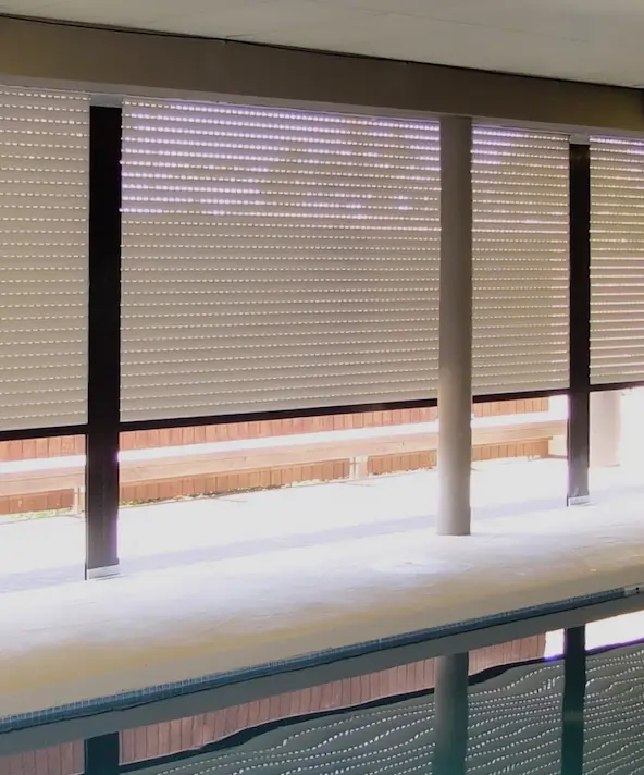 Covered pool enclosed by retractable shutters.